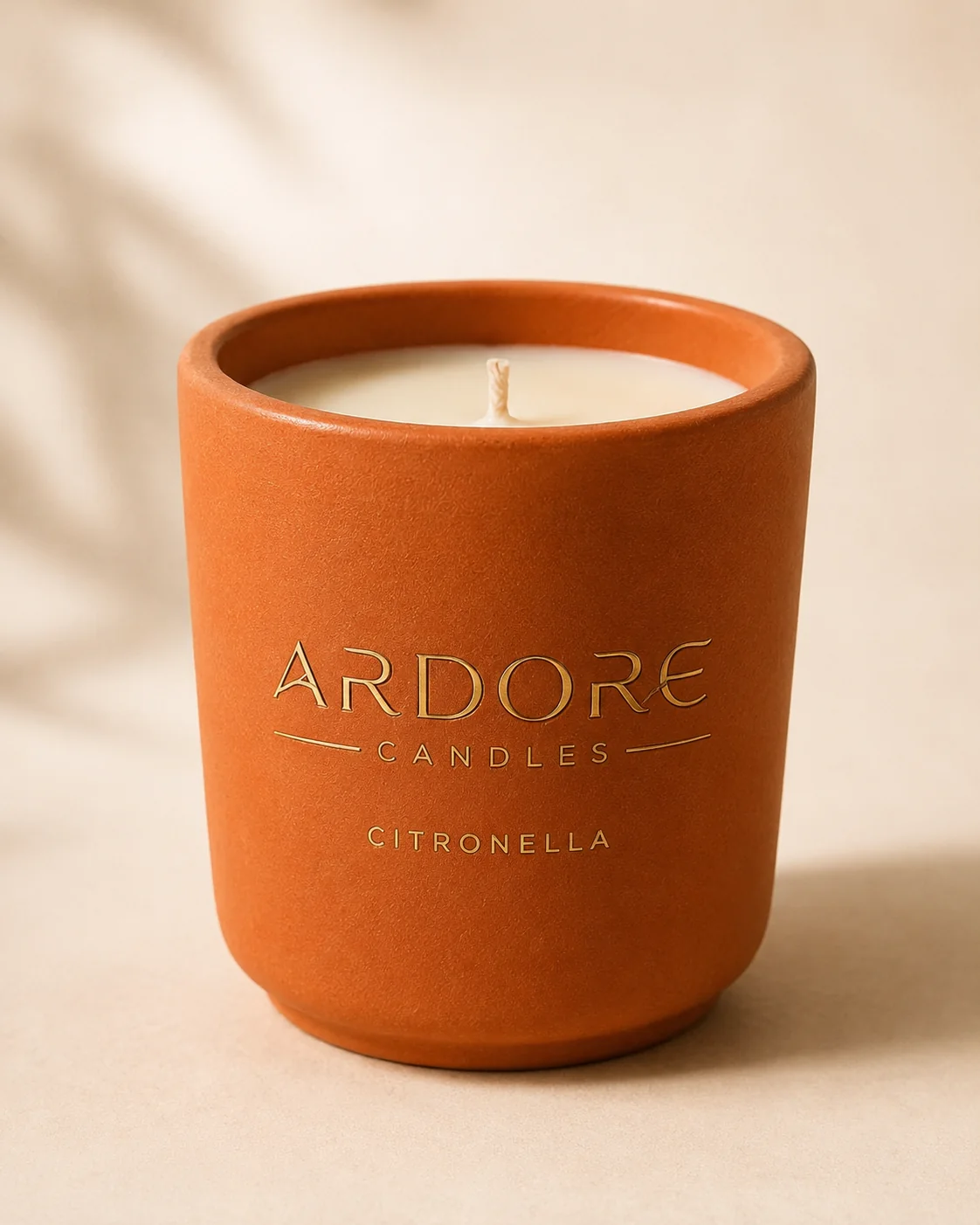 Close-up van de terracotta Citronella Pot met gouden Ardore-logo en katoenen lont